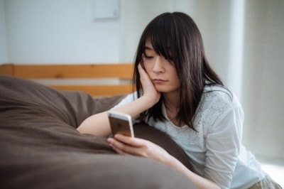 退屈そうにスマホいじる女